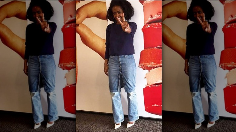 Woman wearing denim skirt over jeans