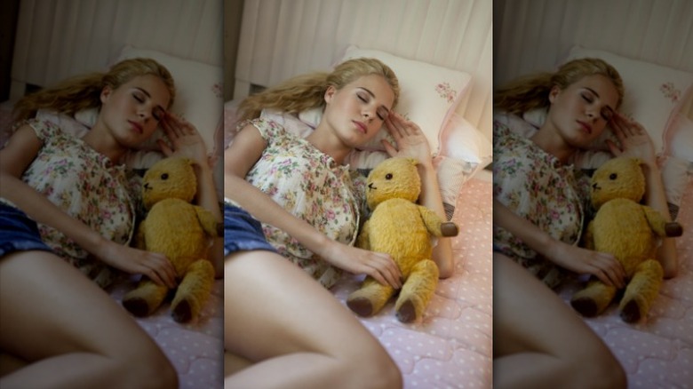 Woman sleeping with stuffed bear