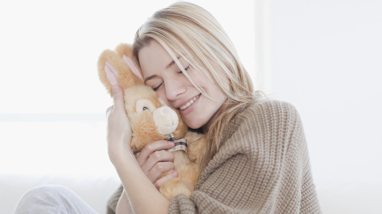 Woman hugging stuffed rabbit toy