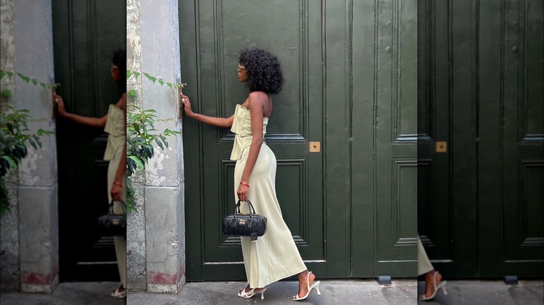 Woman wearing long slip skirt and top with white slingbacks