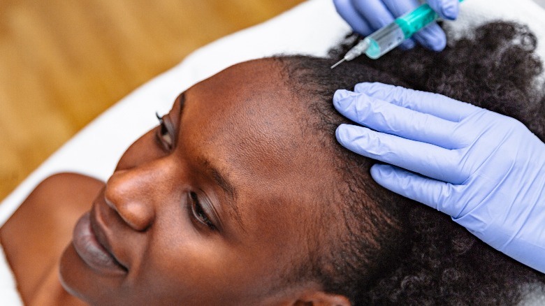 Woman receiving injectable treatment into her forehead