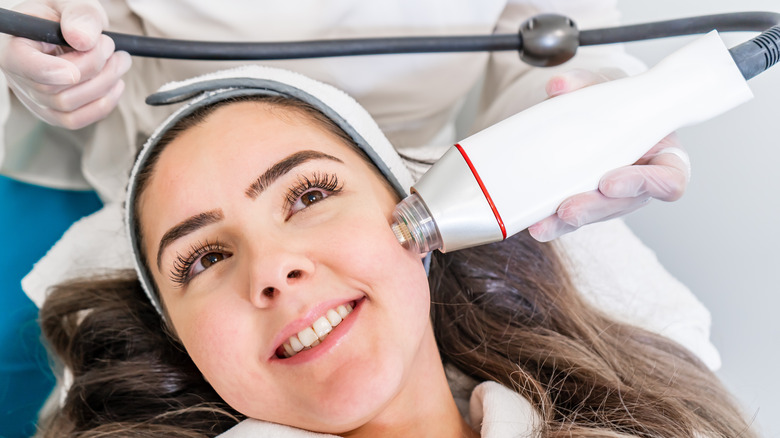 Woman receiving radio frequency dermatology microneedling treatment