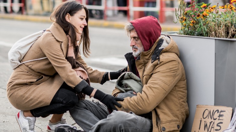 Woman talking to homeless man