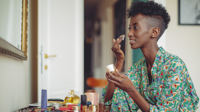 Woman applying moisturizer