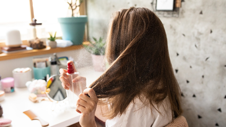 A woman applying hair product