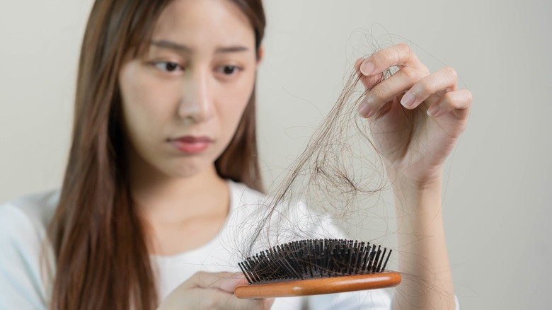 woman looking at hair brush