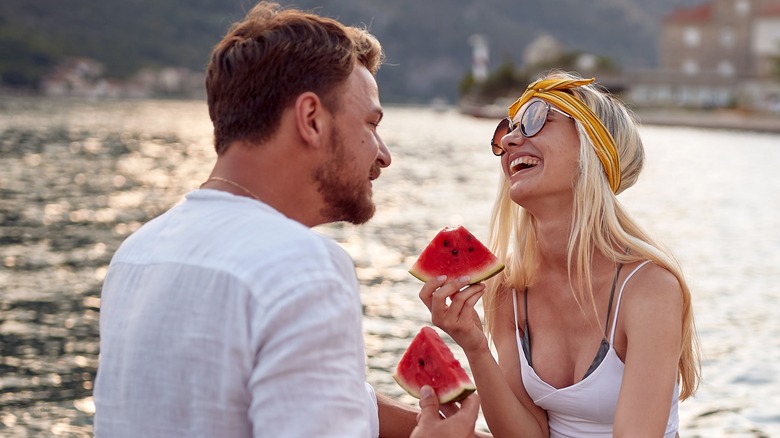 woman eating watermelon with man