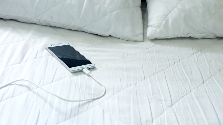 Cell phone charging on bed
