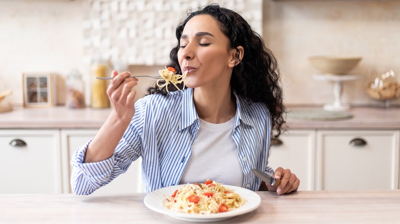 Woman eats pasta