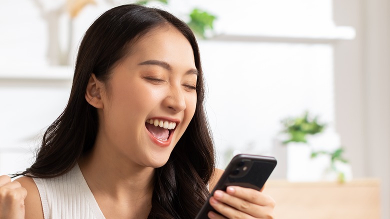 woman laughing at cell phone