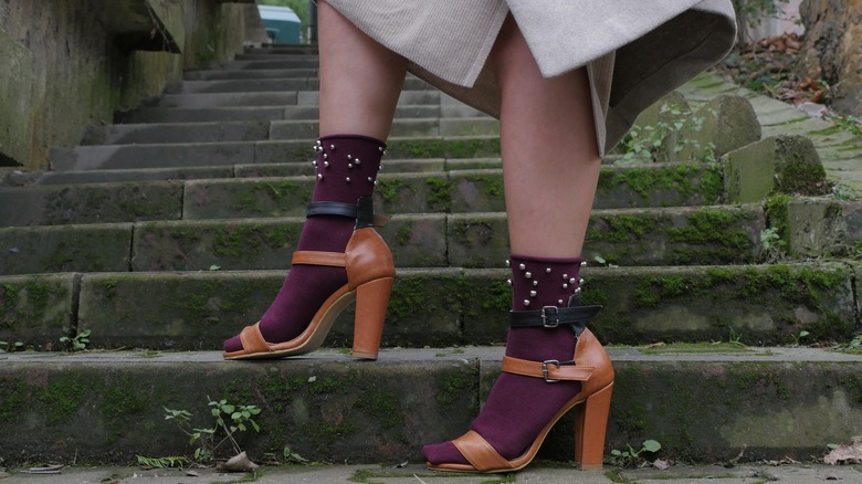 Person wearing burgundy pearl socks with brown heels