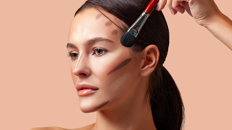 woman applying contour to face