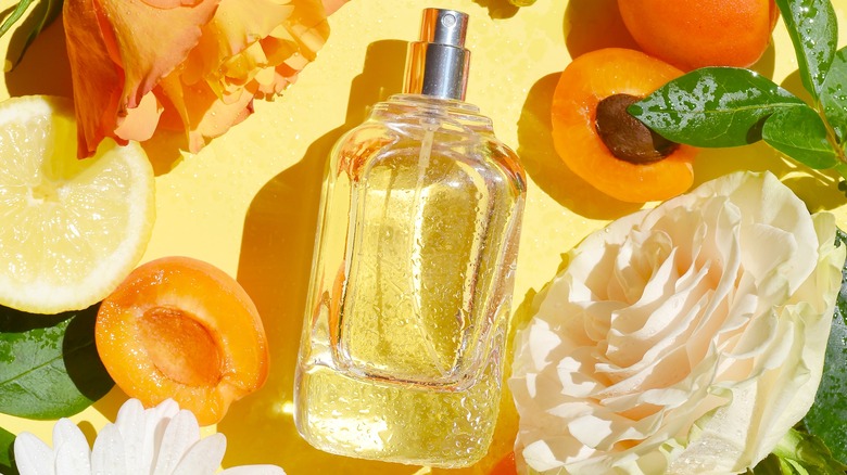 Perfume bottle with apricots, lemons, and roses