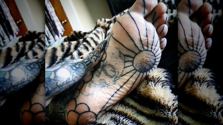 Intricate sole tattoo with sun and skull