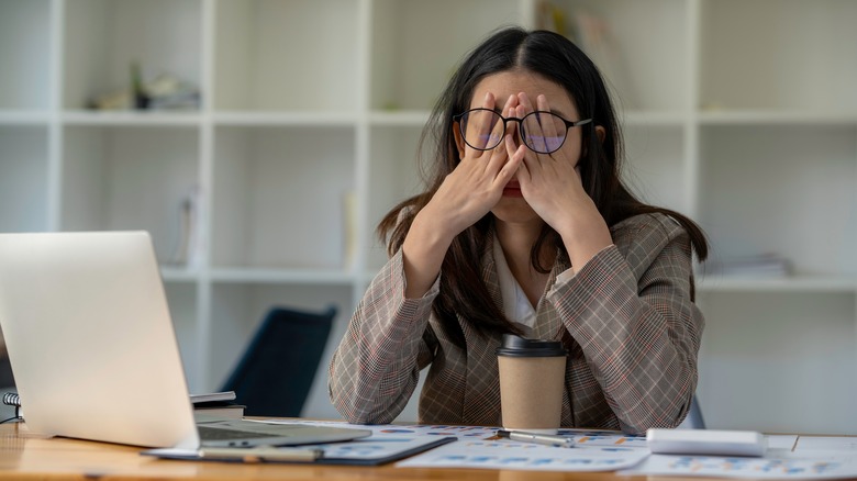 Stressed out woman holds head in hands