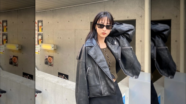 Girl wearing a leather motorcycle jacket.