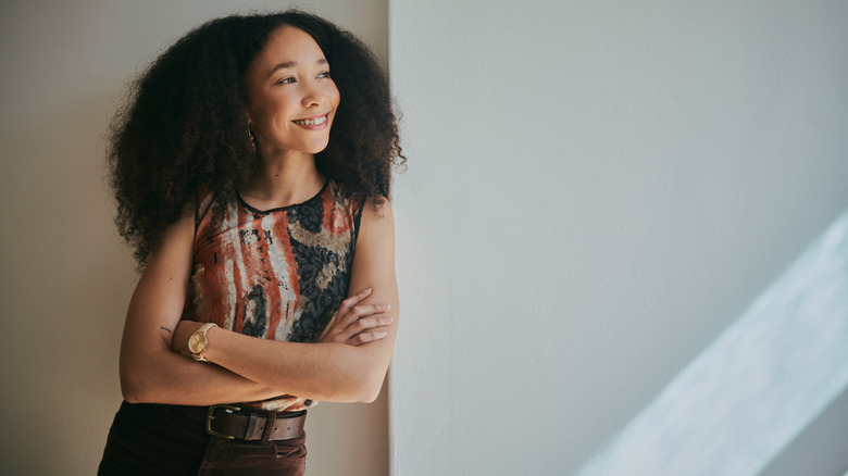 Smiling woman leaning against wall