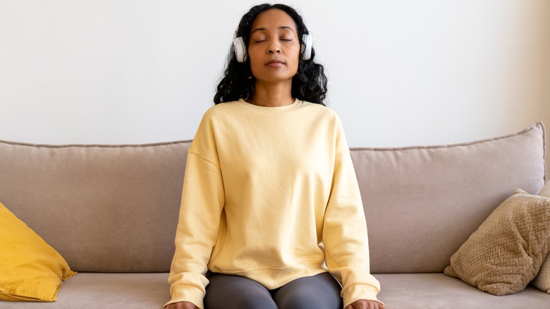 Woman breathes deeply on sofa