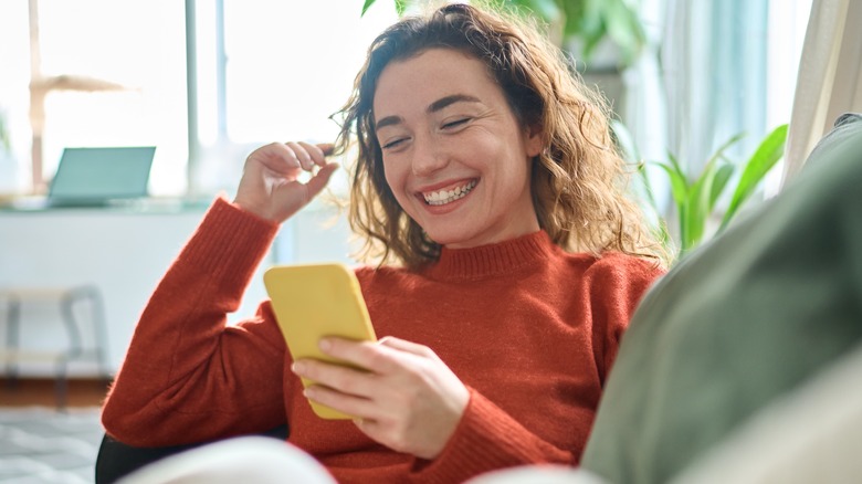 woman smiling and holding phone