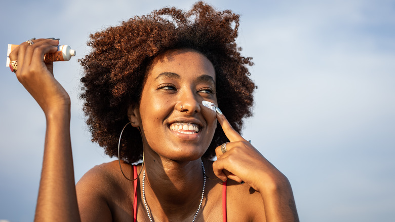 woman applying sunscreen on face