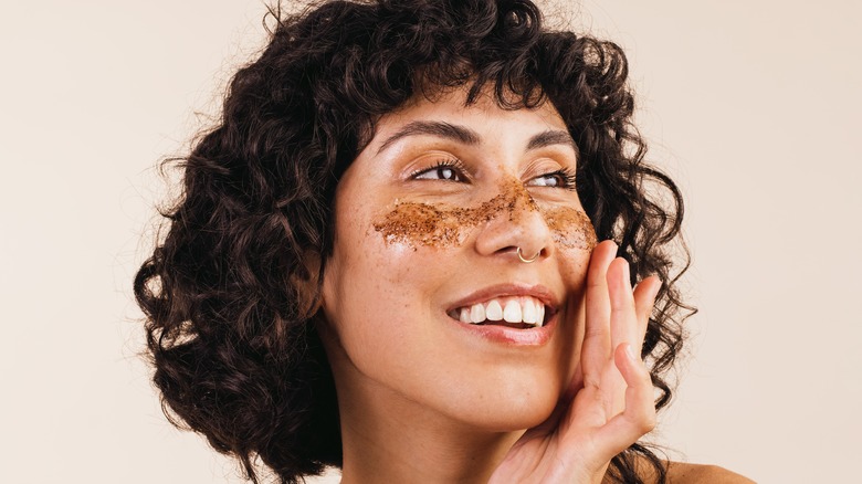 woman with face exfoliator 