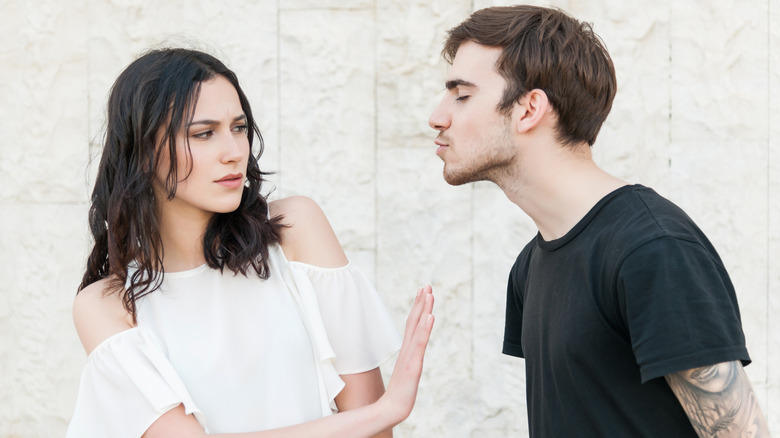 man trying to kiss woman