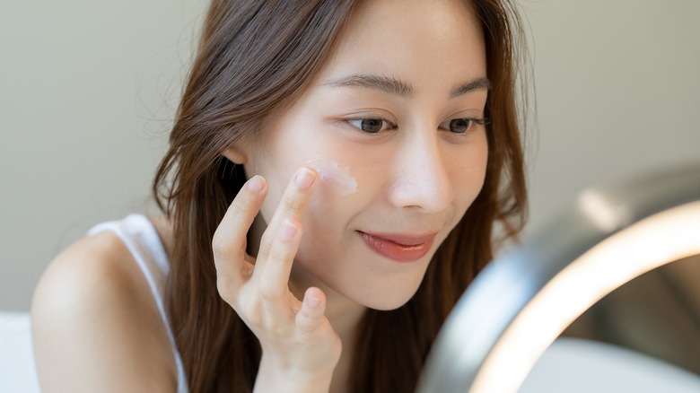 girl applying cream on face