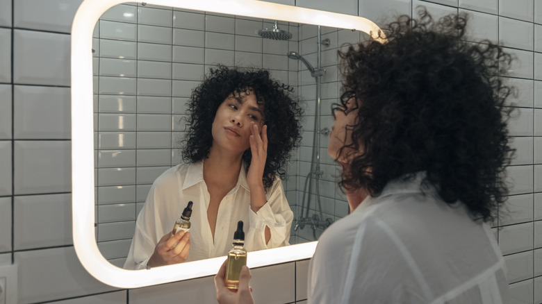 Woman applying serum to face