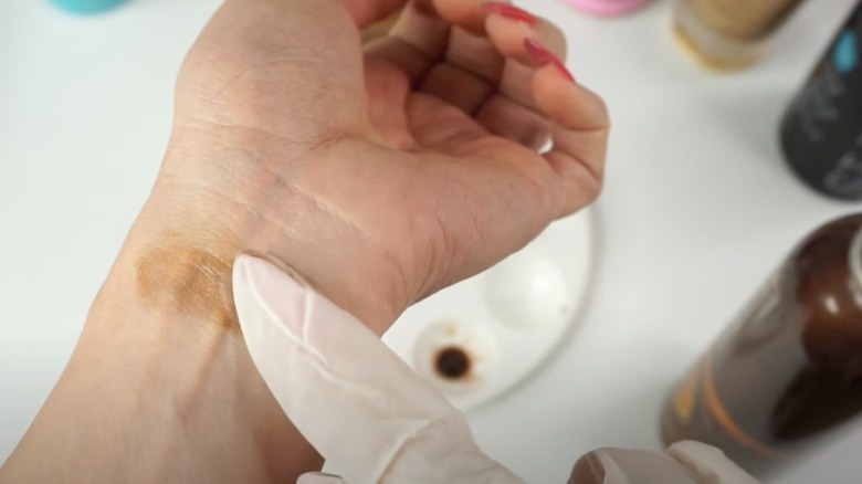 Woman putting patch of tanner on wrist