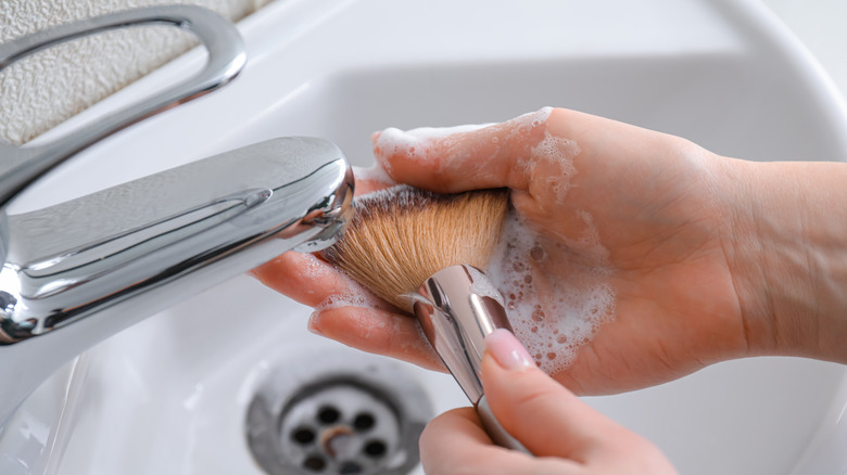 woman washing makeup brush