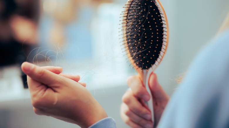 woman cleaning hair out of brush