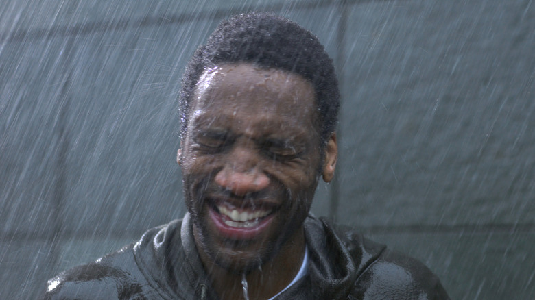 Man smiling outside in rain
