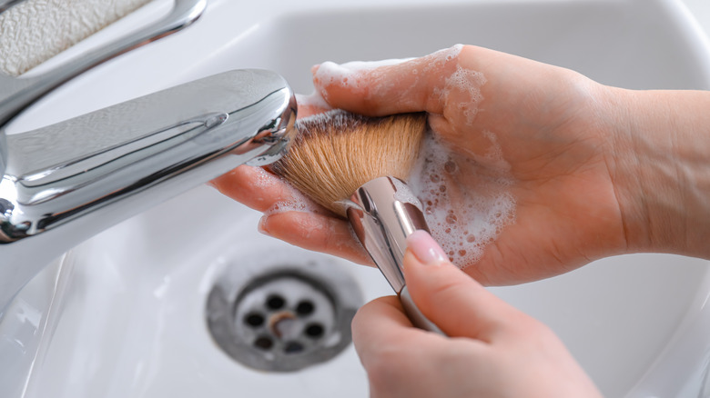 cleaning makeup brush in sink