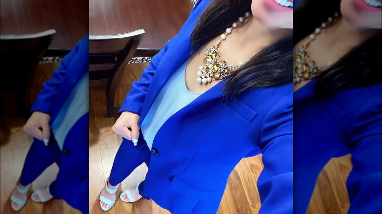 Woman takes selfie wearing blue suit with sandals 