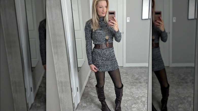 Woman takes mirror selfie wearing sweater dress 