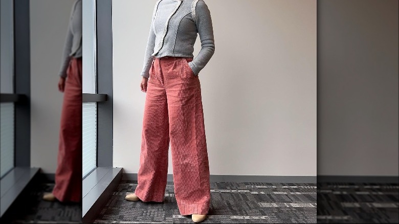 Woman poses in sweater and linen pants 