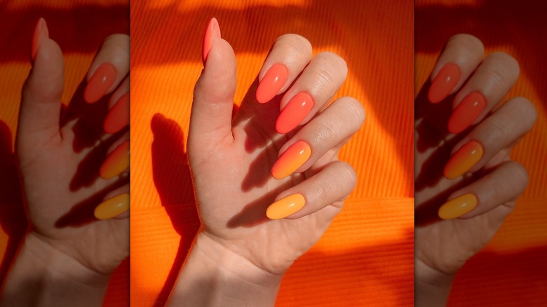 woman's hand over orange background