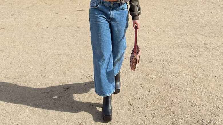 Platform boots and blue jeans on sand