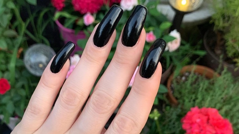 hand with long black squoval nails