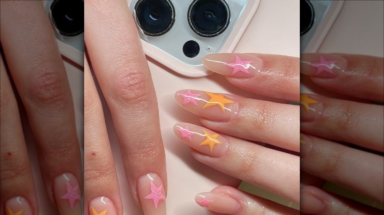 woman with pink orange star nails