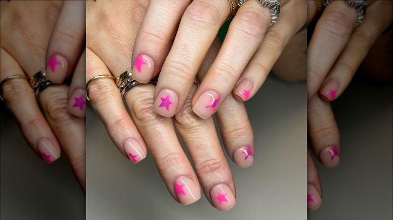woman with pink chrome star nails