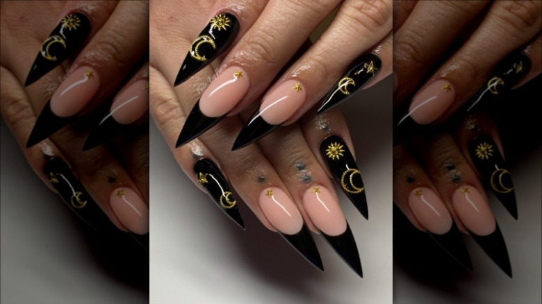 woman with black gold star and moon nails