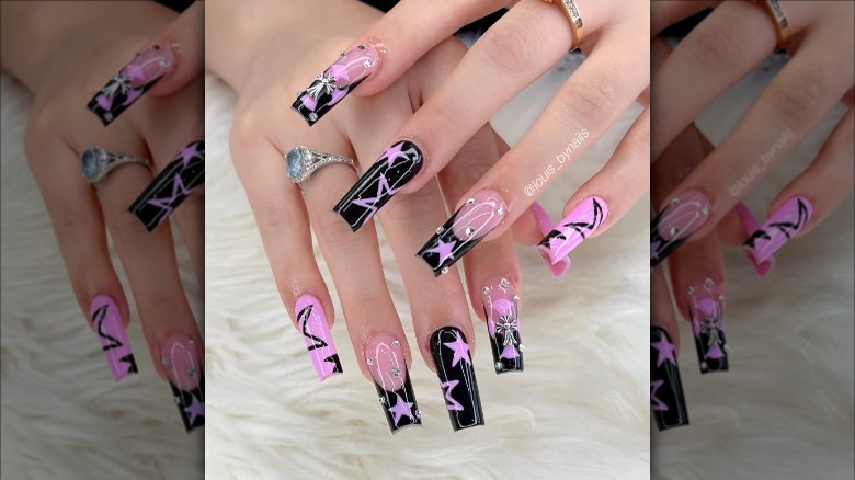 woman with pink and black star nails