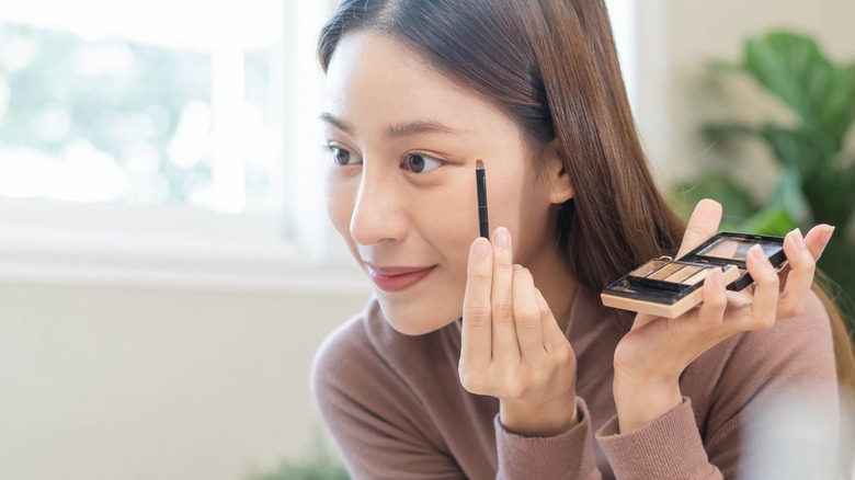 Woman applying eye makeup