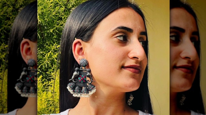 A woman wearing dangly elephant earrings
