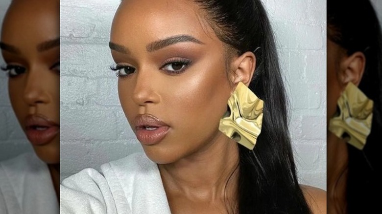 A woman wearing gold foil earrings