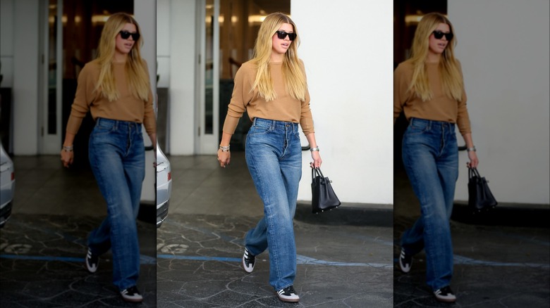 Sofia Richie in tan sweatshirt and jeans