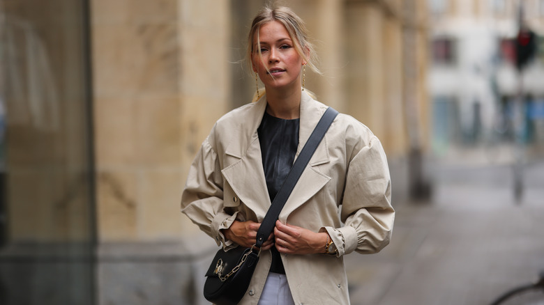 woman in trench coat with bag