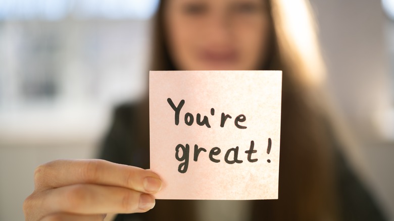 Person holding note with affirmation