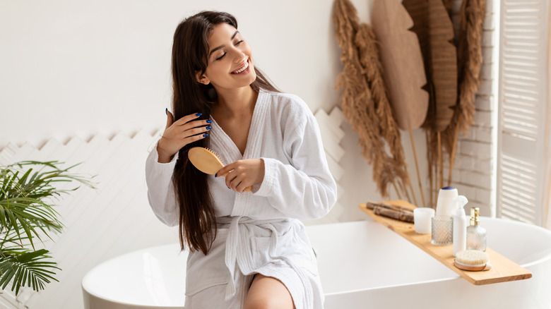 Woman sitting, brushing her hair 